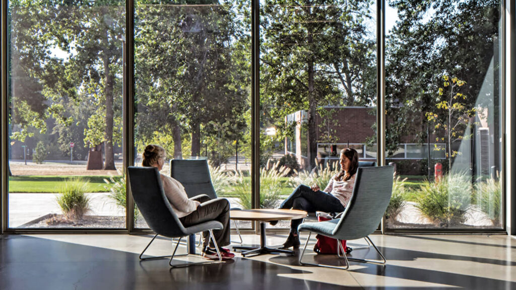 two people sitting in a modern common area in a multifamily development